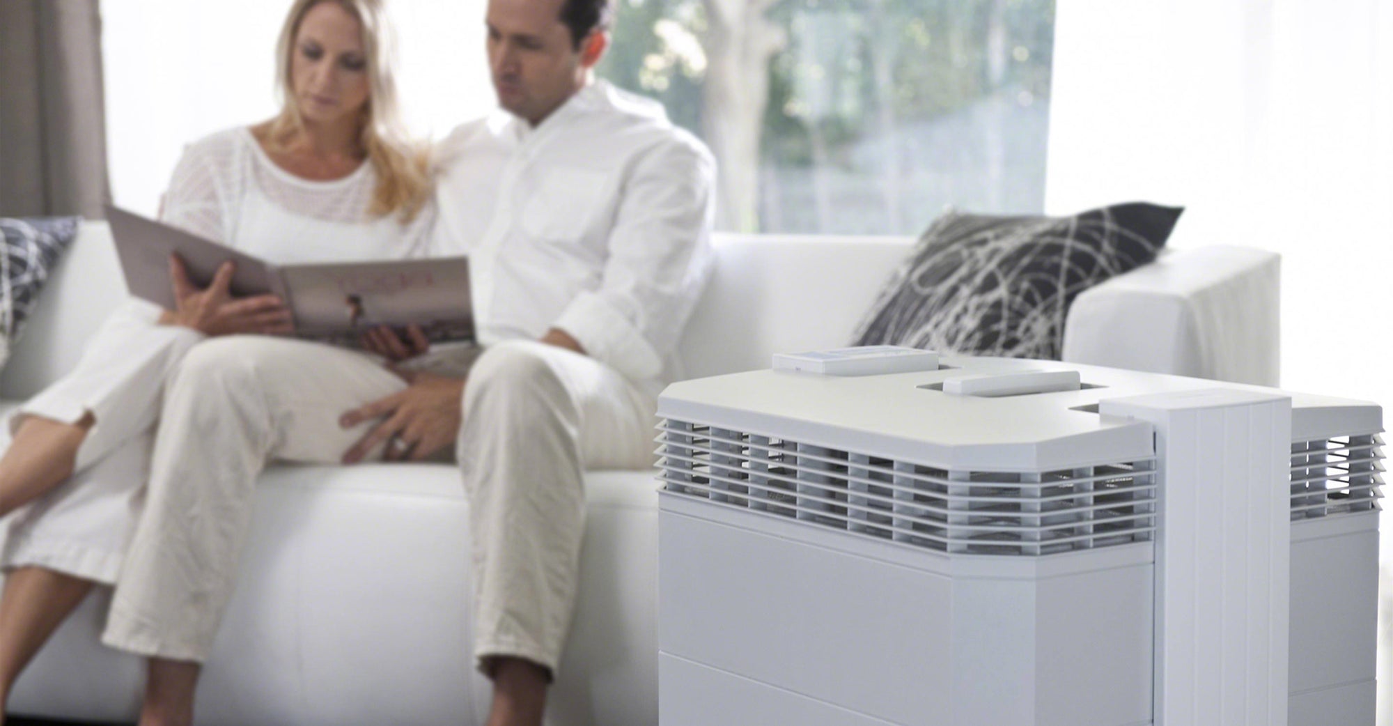Couple sitting on couch enjoying the IQAir HealthPro