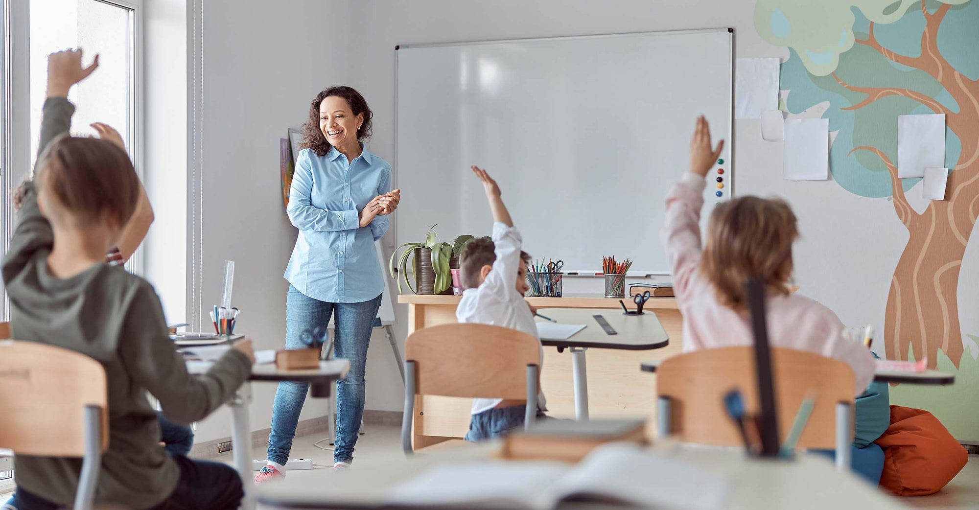 Children raising hands in class